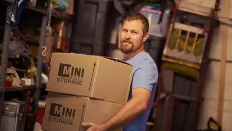 man holding Mini Mall Storage moving boxes for self storage