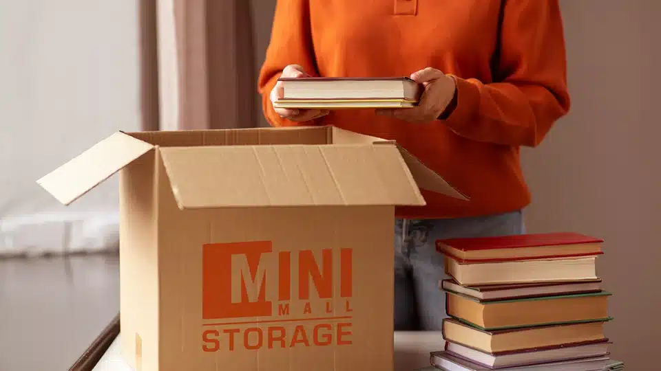 Packing books in a Mini Mall Storage moving box